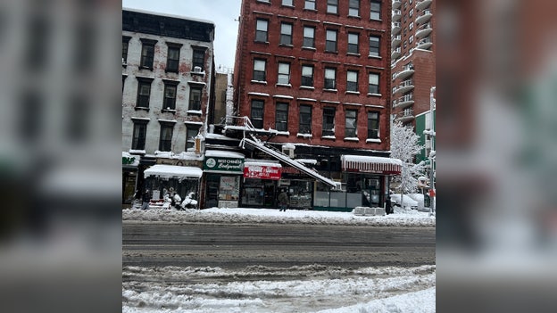Dangling fire escape hangs over sidewalk as nor'easter hammers NYC
