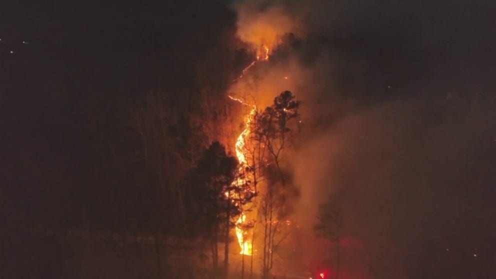 Nighttime drone footage shows a wildfire glowing in neon orange as it burned on a mountainside near Old Fort, North Carolina, on Wednesday, 