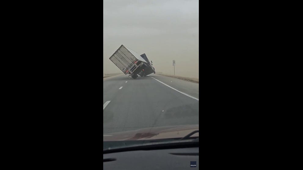 Video shows a semi-truck driving along the highway before the cargo attached to the back of the truck seemingly begins lifting off the ground.