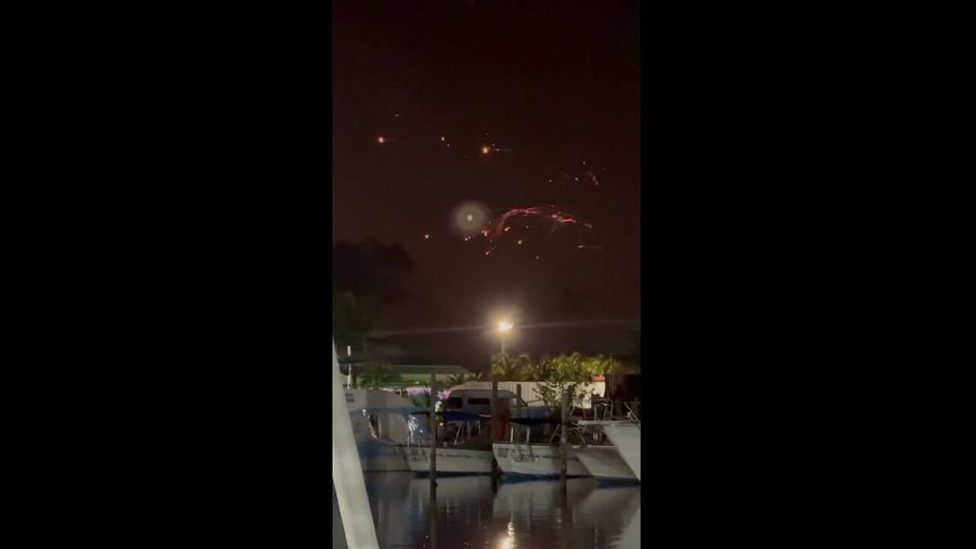 Onlookers from the Turks and Caicos Islands observe the fiery scene of the SpaceX debris falling from the sky.