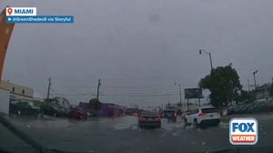 Motorists drive through floodwater in Miami amid Flash Flood Warning