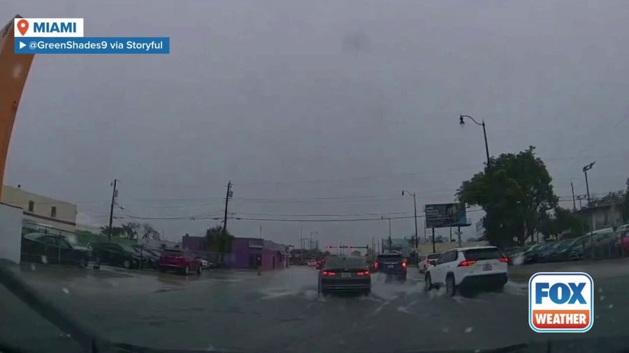 Motorists drive through floodwater in Miami amid Flash Flood Warning