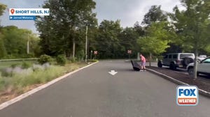 Intense winds blow away umbrella at New Jersey golf course. 