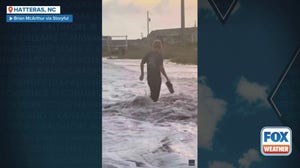 Waves from Hurricane Erin knock man off of sand dune