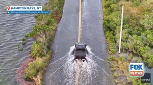 Cars drive through flooding produced by Hurricane Erin on Long Island