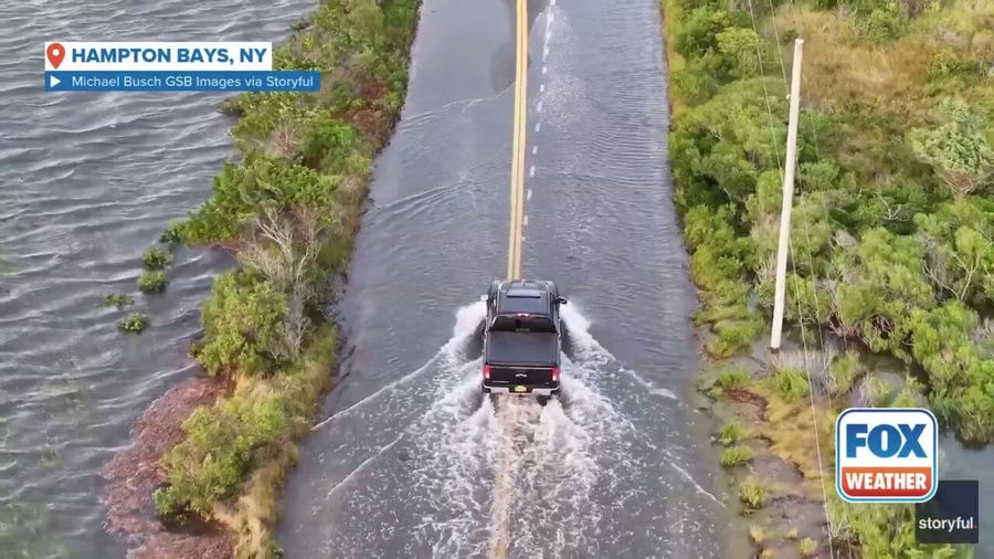 Cars drive through flooding produced by Hurricane Erin on Long Island