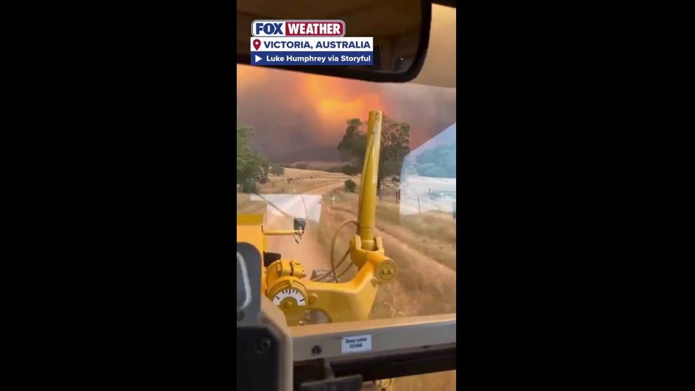 A man in Victoria, Australia, tries to use heavy machinery to help fight widespread flames.