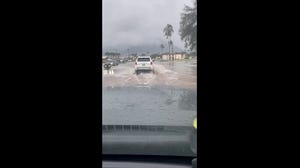 Motorists navigate through flooded Maui streets 