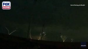 Upward lightning shoots into sky from wind turbines
