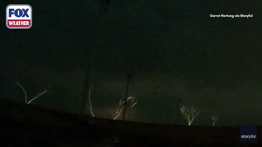 Upward lightning shoots into sky from wind turbines
