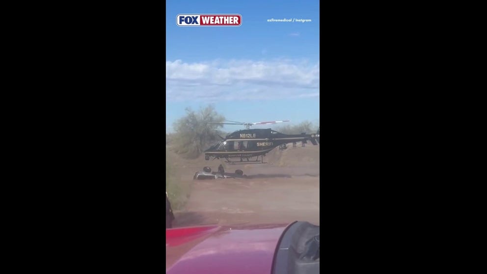 An Arizona driver becomes stuck in flooding after severe weather brings heavy rain.