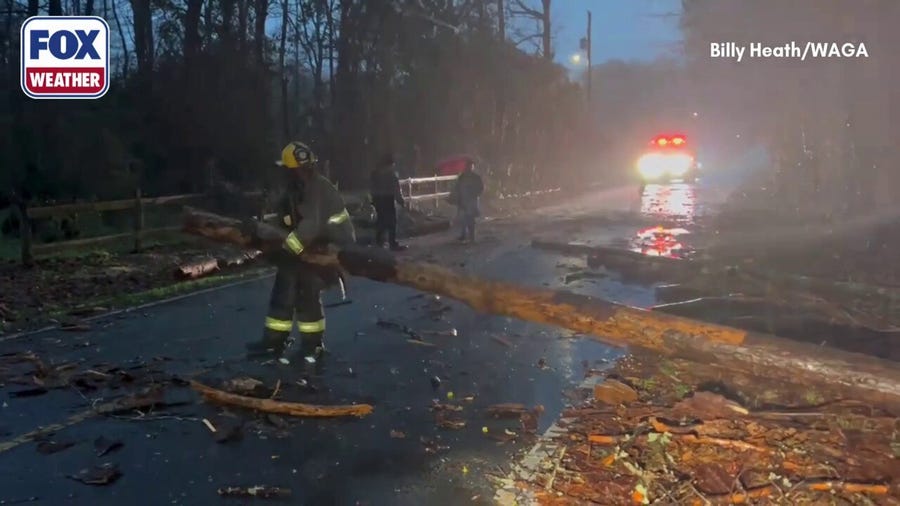 Firefighters clean up tree debris after tornado-warned storm rumbles through Rockdale County, Georgia