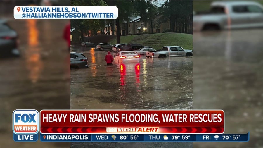 Birmingham, AL resident unclogs drain to help reduce flooding in parking lot