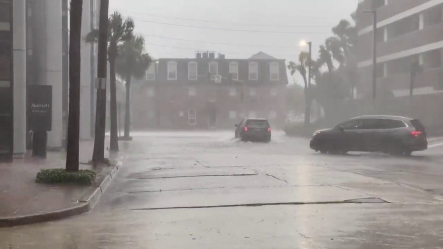 Cars plow through a flooded New Orleans