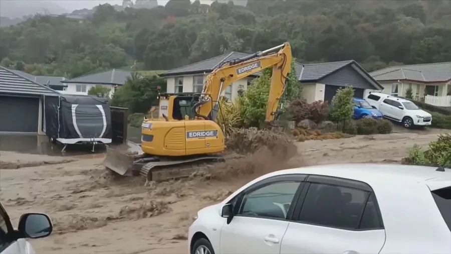 Construction truck tries to navigate flooded roadway after dam break in New Zealand