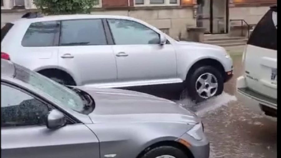 Car drives through flooded Chicago street