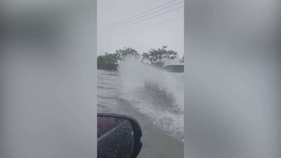 Cars plow through floodwaters in Doral, FL