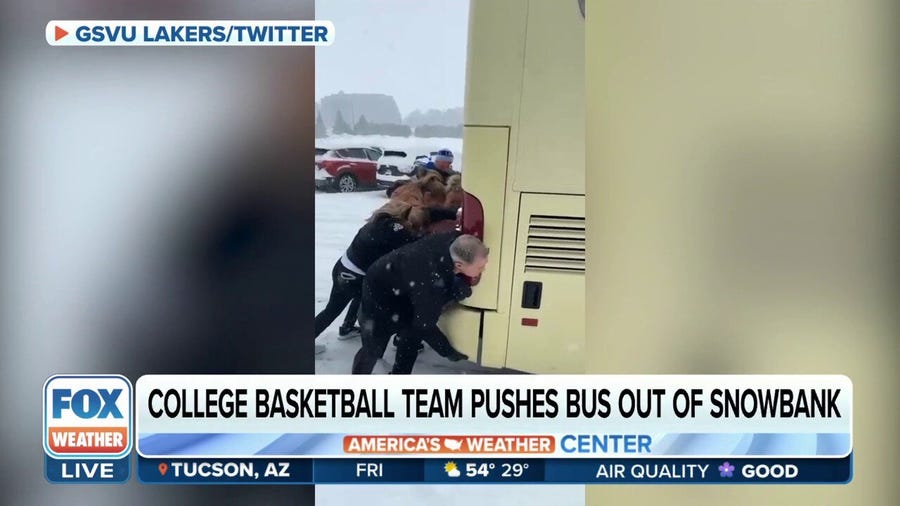 Grand Valley State University women's basketball team pushes bus out of snowbank