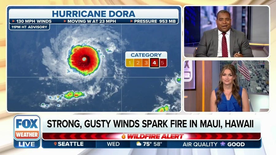 Hurricane Dora continues to trek well south of Hawaii as raging wildfires burn in Maui