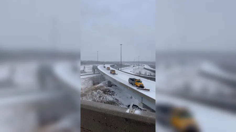 Missouri Department of Transportation trucks plow snow-covered Kansas City roads