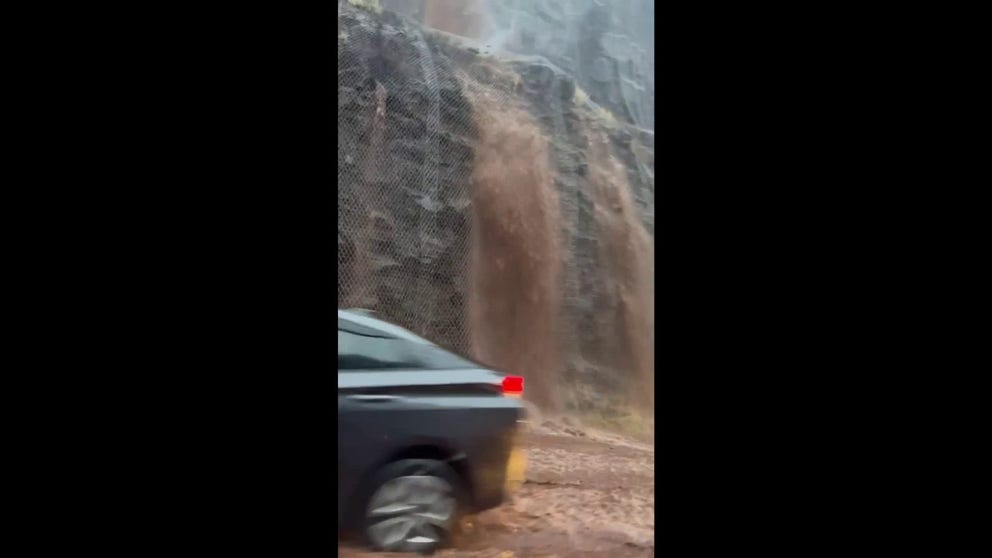Heavy rains turn highway cliffs into waterfalls spilling onto Maui's roads.