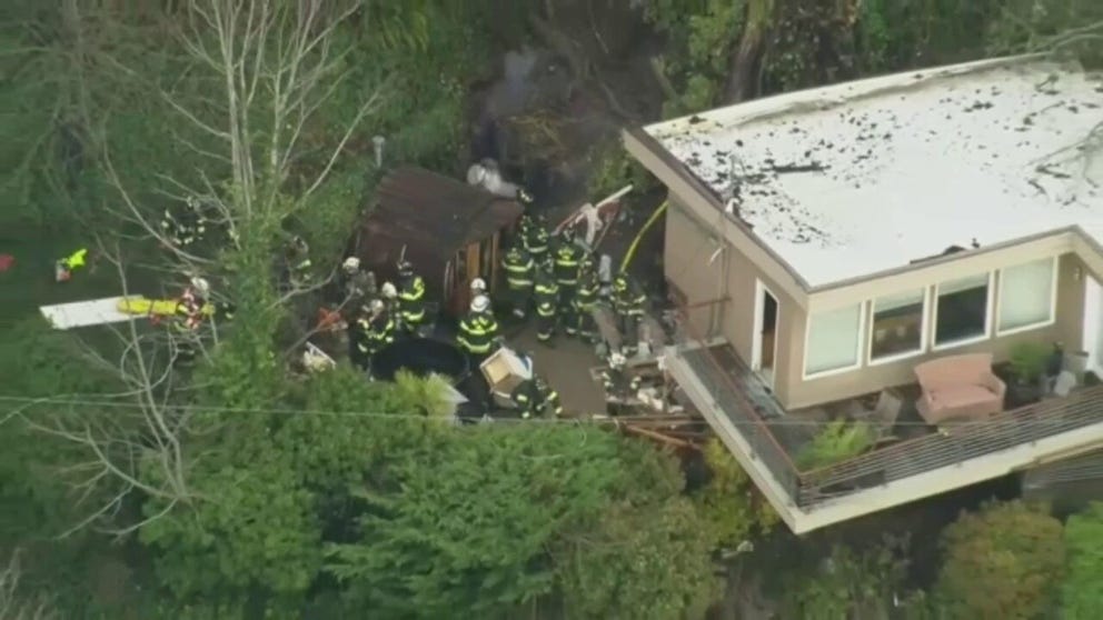 A mudslide crashed into a home on a bluff in Seattle, trapping a man inside and killing a pet dog.