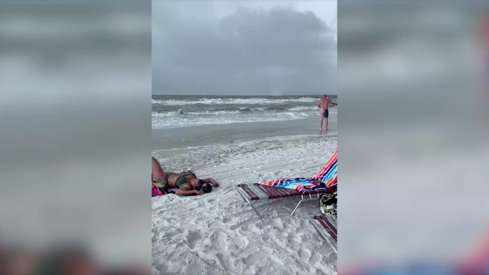 Fort Myers beachgoers ran for safety on Saturday as a waterspout moved onshore in Florida. 