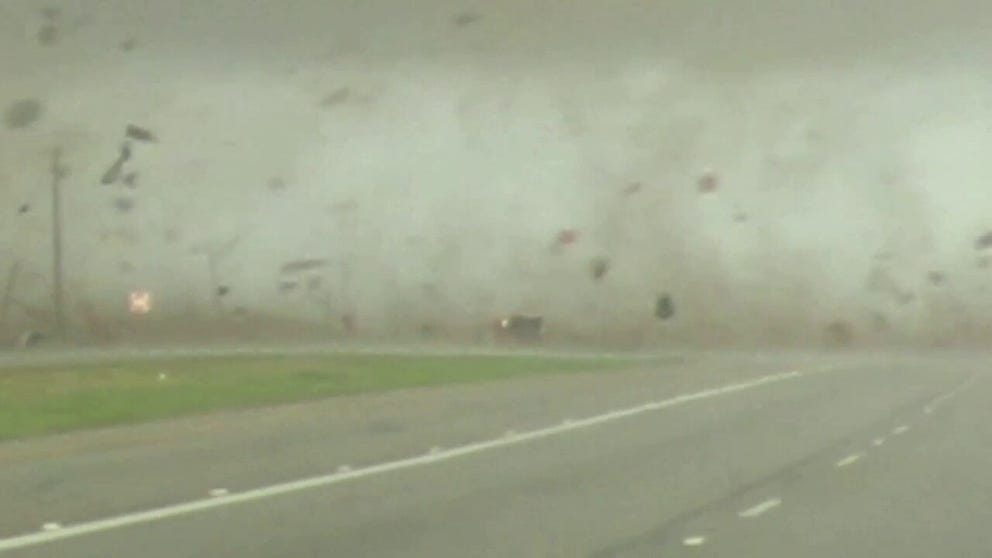 This is video of the Elgin, TX tornado crossing the road and hitting a red truck. The truck is blown over on its side , spins, and is then blown back right side up. A second later the driver drives away.