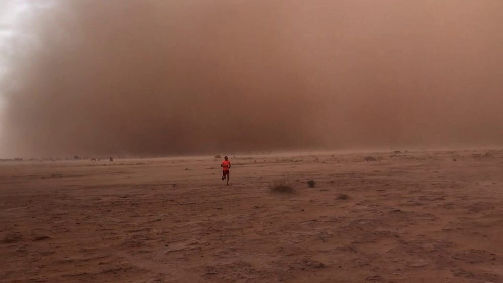 A person running from a surface dust storm in M´Hamid, Morocco in September 2019. NASA's EMIT instrument will measure the Earth’s arid regions to enable new modeling and understanding of the Earth’s mineral dust cycle.