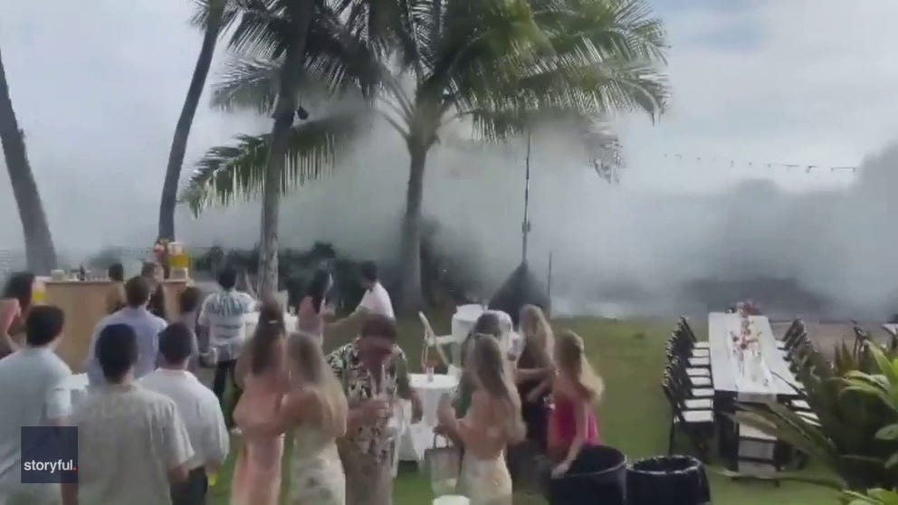 Watch as huge waves cause a wedding party to run at a Hawaii coastal resort. These waves come from the remnants of Hurricane Darby. 