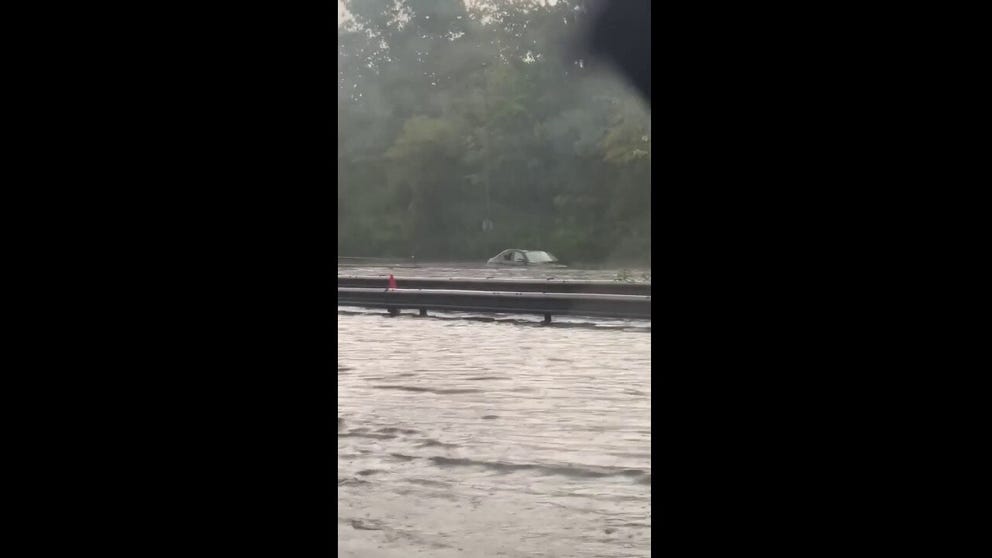 @TheTallet posted on Twitter this video of an abandoned car. She presumes the occupants had to break the back window to escape the flood,.