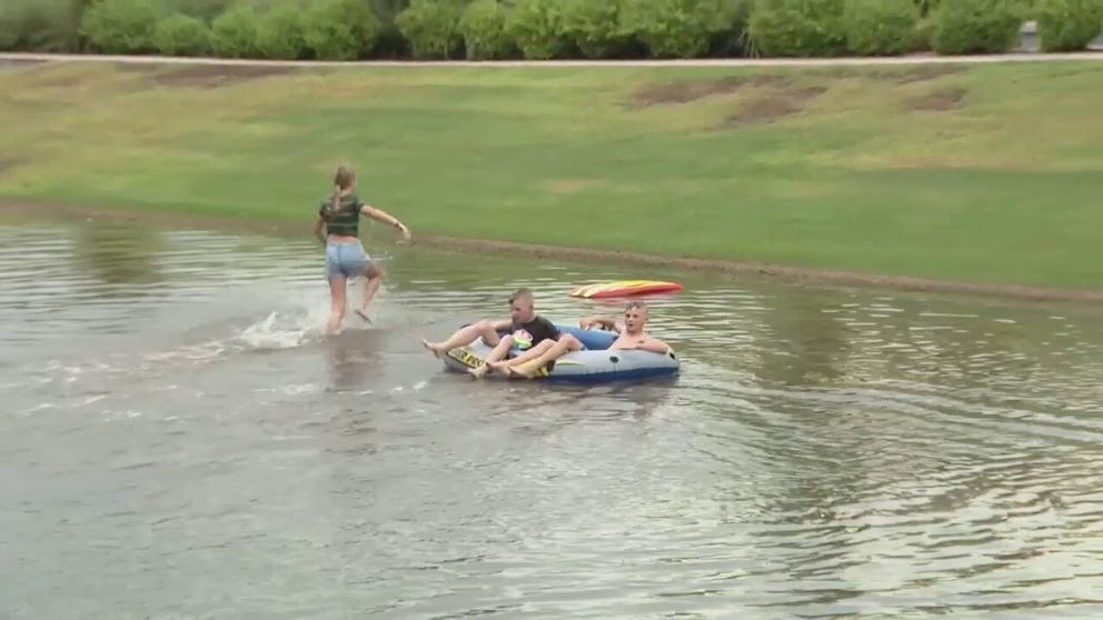Kids in Gilbert take advantage of the new 'pools' created by floodwaters.