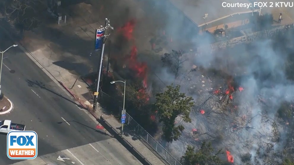 KTVU FOX 2 chopper footage show the vegetation fire burning along I-580 in Oakland, California. 