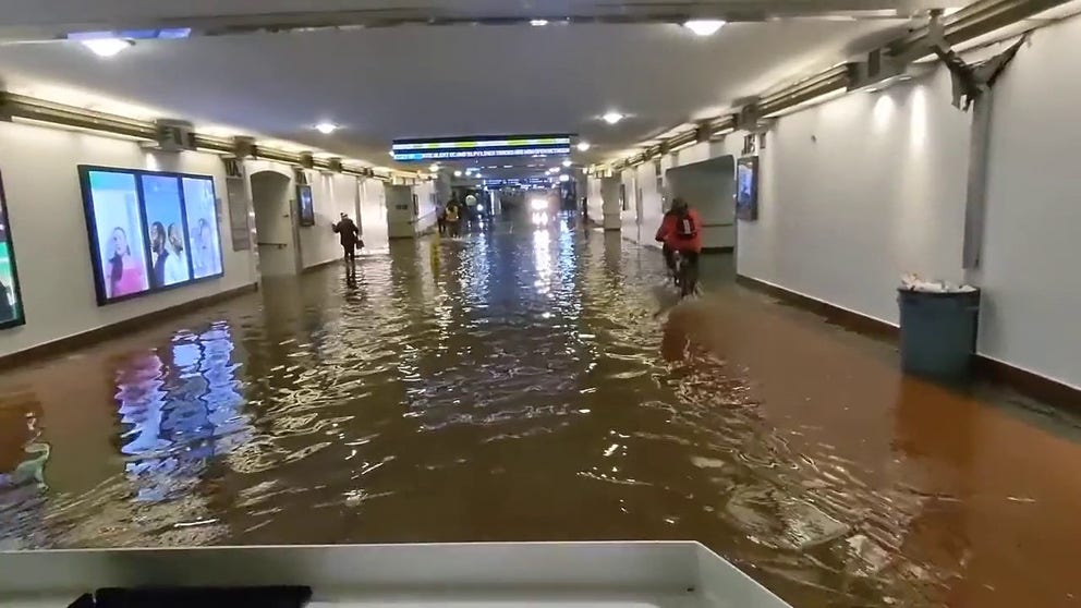 Metro passenger Sandy Eckel gets a ride through Los Angeles' flooded Union Station on Tuesday. 