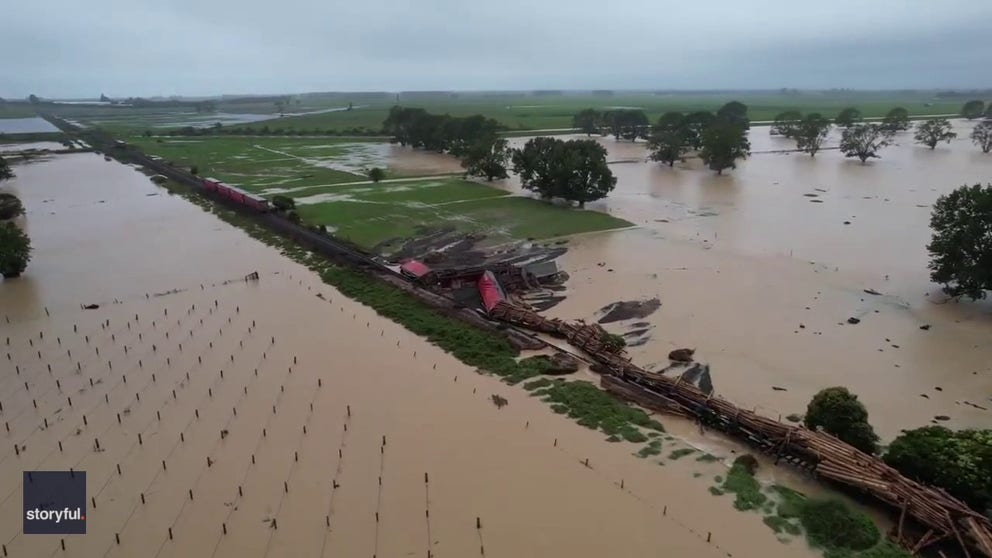 Footage captured by David Holwerda shows extensive flooding around the train track, with logs that the train had been carrying spilled into the floodwater.