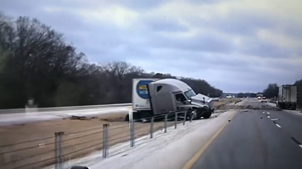 Oklahoma Highway Patrol trooper captures the moment when a large truck spun out of control and hit a highway barrier in Sequoyah County. An ice storm has brought dangerous travel conditions to the South on Tuesday. (Credit: @OHPDPS/ Twitter)