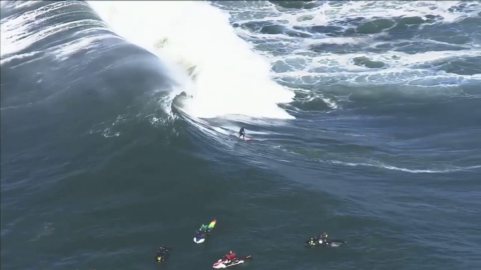 File: Aerial footage of surfers catching waves at Mavericks.