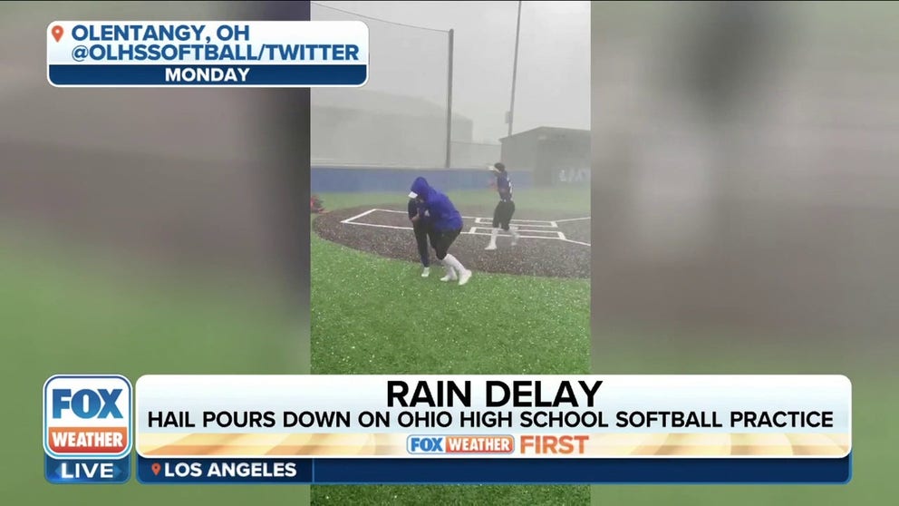 Hail pours down on a high school softball practice in Olentangy, Ohio. Players are seen running for cover during the storm. 