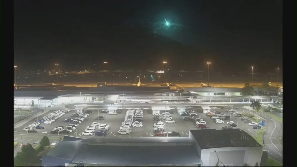 Video captured at Cairns Airport in Queensland, Australia, shows a meteor flashing a bright green as it streaked across the night sky and fell to Earth.
