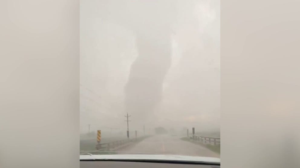 In this video, a driver speeds away from a tornado in reverse in Scottsdale, Nebraska. June 23, 2023. (Courtesy: Christopher Vohland / Facebook)