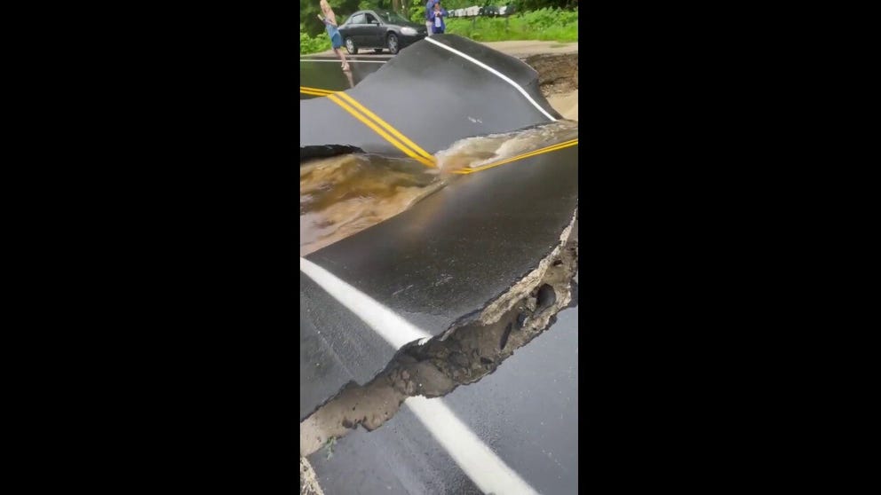 A road in Hillsboro, New Hampshire, collapsed on Sunday amid torrential rain and flood warnings within the state. (Courtesy: Isaac Bailey via Storyful)
