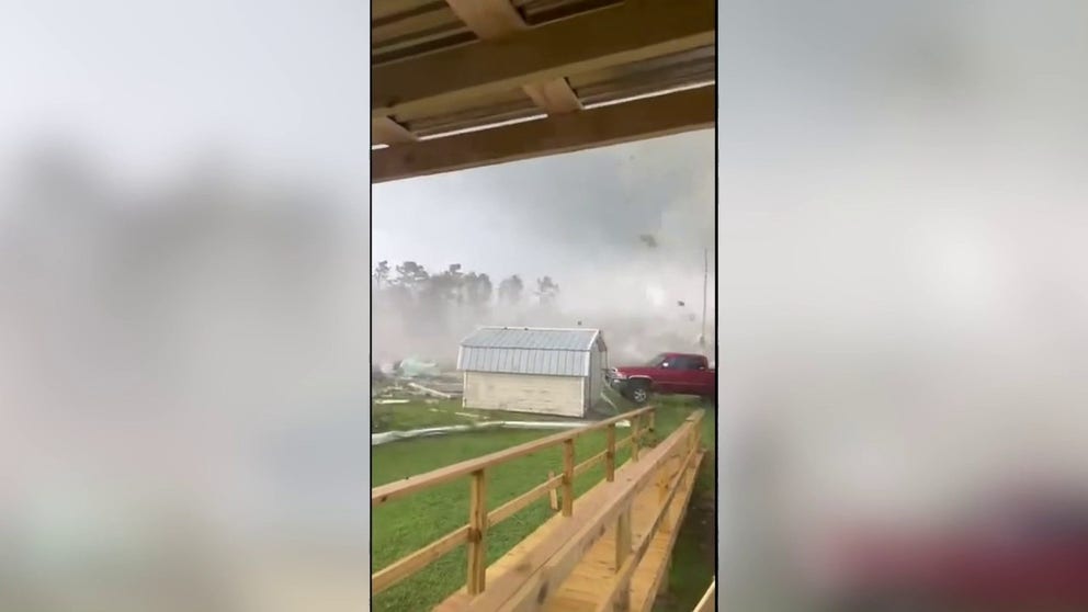 A video shared by Claudius R. Brewer shows a tornado picking up debris and peeling the roof off a structure Wednesday in Dortches, about 50 miles northeast of Raleigh, North Carolina.