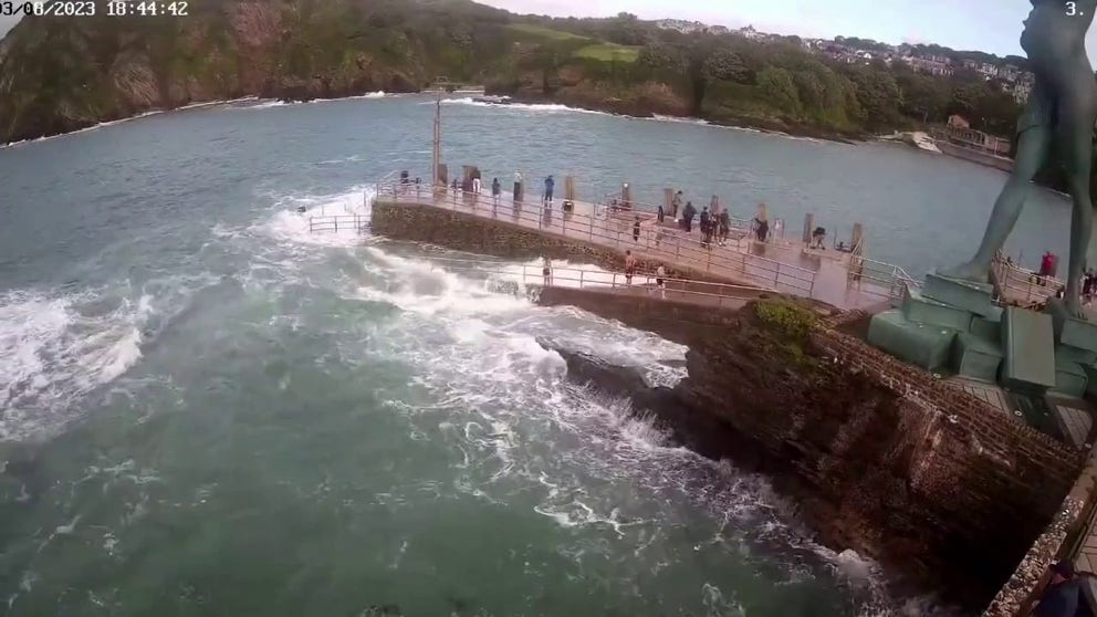 A dramatic video recorded in England shows a large wave sweeping a child out to sea, and then a group of people working together to make a dramatic rescue.