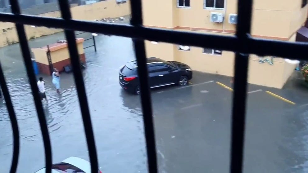 Heavy rains from Tropical Storm Franklin swamped cars in parking lots in Santo Domingo Este. The republic issued red alerts for flash flooding.
