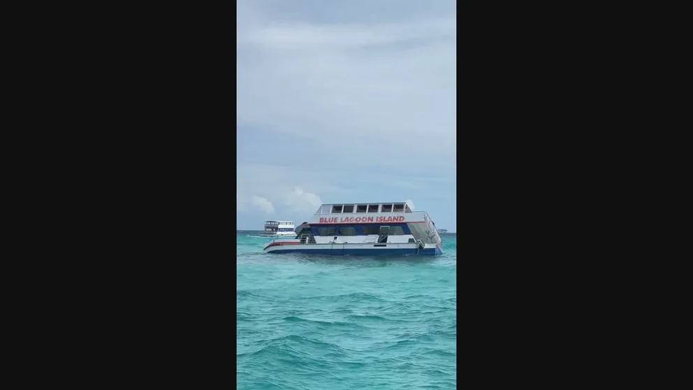 A dramatic video shows chaos as a boat heading to the popular tourist destination Blue Lagoon Island in the Bahamas taking on water and sinking.