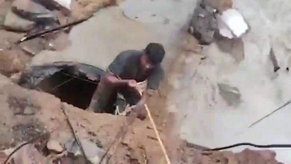 Video in Chennai, India shows local police helping a man trapped in a deep hole with racing floodwaters. The rescue happened as Chennai received extremely heavy rainfall from a cyclone storm, according to the India Meteorological Department. 