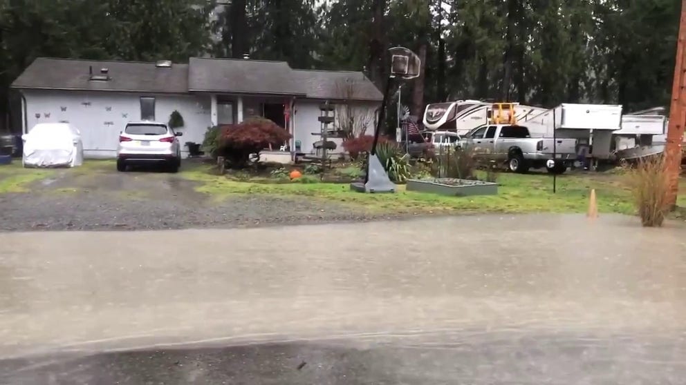 Video recorded in Granite Falls, Washington, shows floodwaters covering roads and flowing from homes after the Stillaguamish River overflowed its banks on Tuesday.