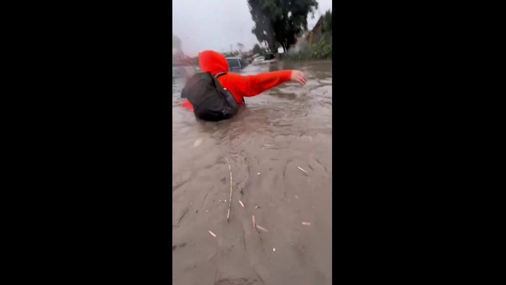 Listen to the fear and exhaustion as two San Diego residents struggle, wading through waist-deep flood water to escape their family home.