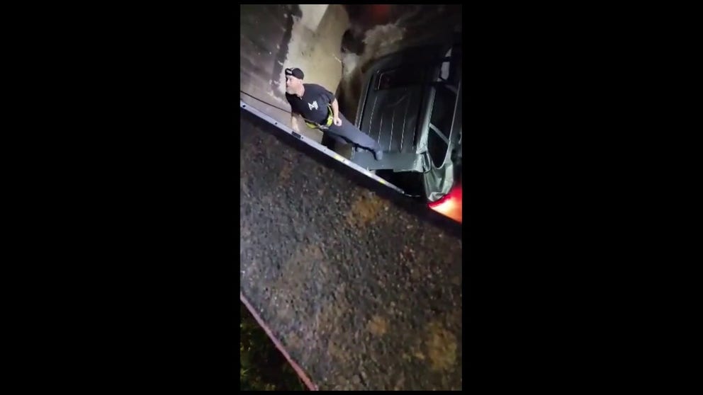 Listen to the rushing water as the fire department lowers a ladder down to a man who lost control of his vehicle and ended up in a flood-swollen canal, trapped. The wrecker crew still couldn't retrieve the car a day later because of the fast current.