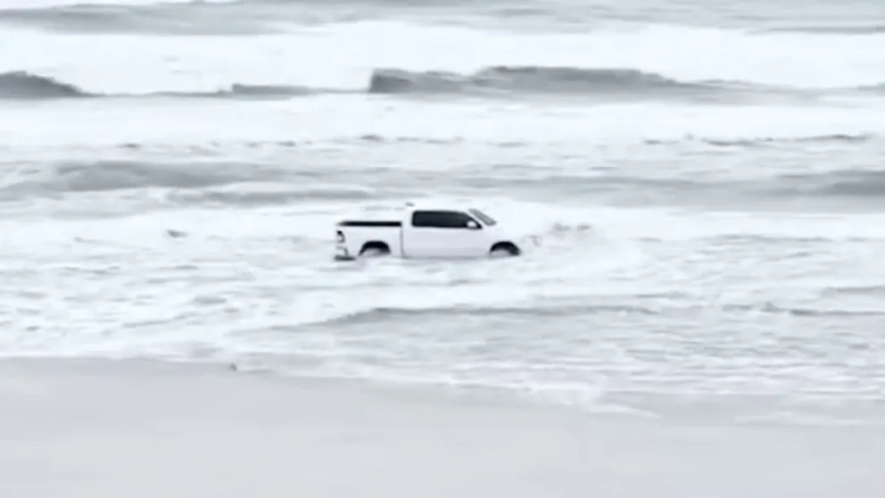 Bystander video and Volusia County Sheriff's Office body camera video shows a man accused of driving on the beach in New Smyrna Beach when the beach access was closed due to high surf. 